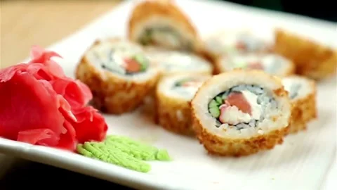 Fried sushi rolls with ginger and wasabi on plate Stock Footage 333875690