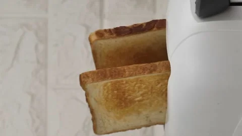 Fried toast bread pops out of a white modern toaster. vertical screen Stock Footage 259338724