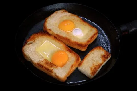 Fried toasts with egg inside in a pan. Traditional french dish. Rustic breakf Foto stock