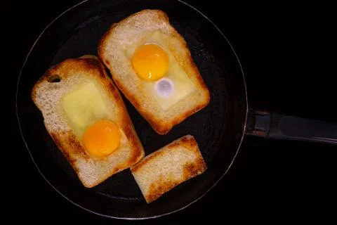 Fried toasts with egg inside in a pan. Traditional french dish. Rustic breakf Stock Photos