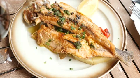 Fried trout carcass, complemented with lemon and edible green Vídeos de archivo 283946929