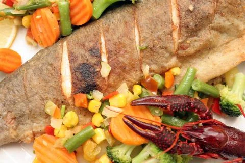 Fried trout with vegetables.  Stock Photos
