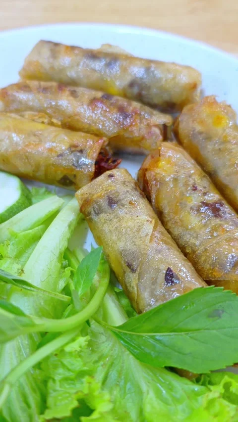 Fried vegetable spring rolls. Crispy spring rolls served on white plate. Stockbeeldmateriaal 337126893