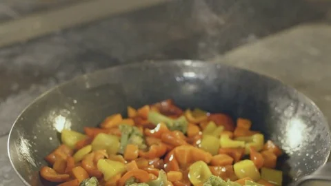 Fried vegetables in a griddle, slow motion Stock Footage 70386422