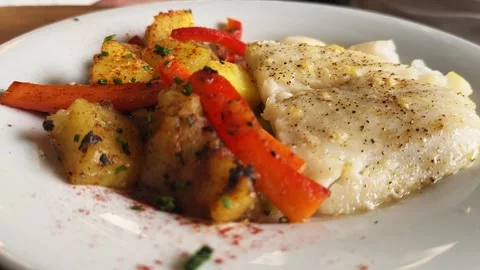 Fried white fish garnished with grilled vegetables on a plate. Sea bass fillet Stock Footage 312801492