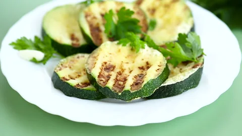 Fried zucchini slices on a green background Stock Footage 313954942