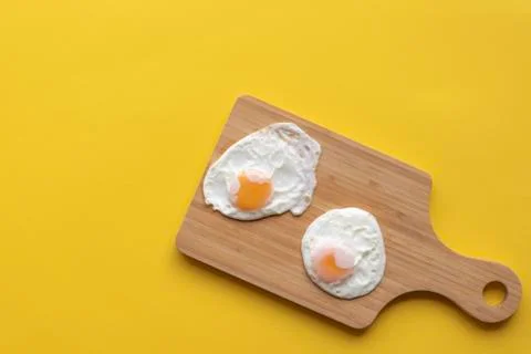 Friedd eggs on a cutting board Stock Photos