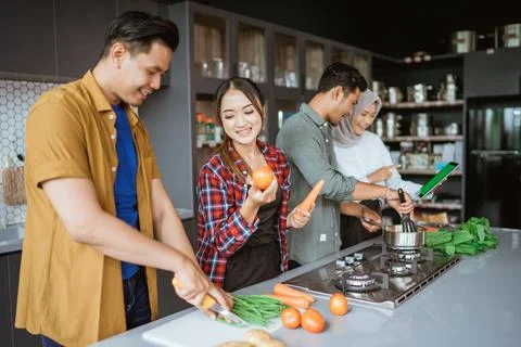 Friend cooking together in the kitchen while looking at online course from 스톡 사진