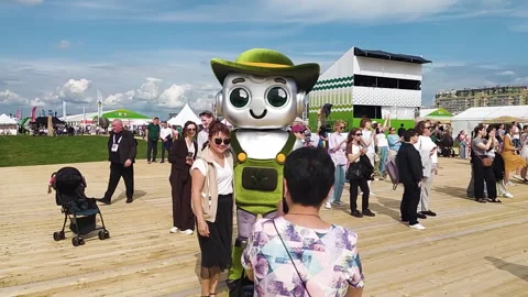 A friendly actor, promoting in a childish robot suit at the event, amuses people Stock Footage 317921390