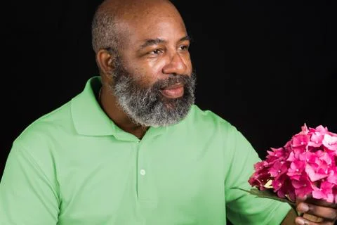 Friendly African American with colorful  hydrangea flower on black background Stock Photos