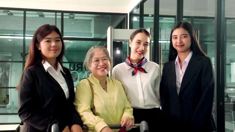 Friendly airline ground staff posing with an elderly passenger at the airport Stock Footage 321000173