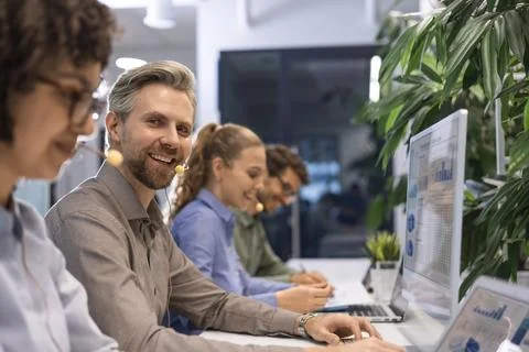Friendly and helpful customer service support specialists in work Stock Photos