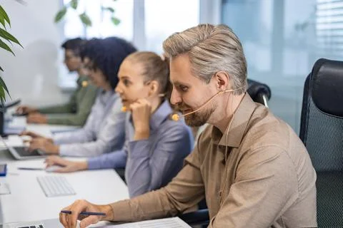 Friendly and helpful customer service support specialists in work Stock Photos