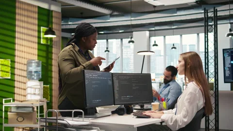Friendly coworkers helping junior dev code AI algorithms to debug software Stock Footage 313018450