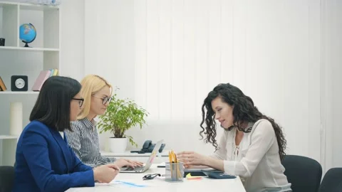 Friendly creative diverse colleagues team discuss project using computer at Stock Footage 137807097