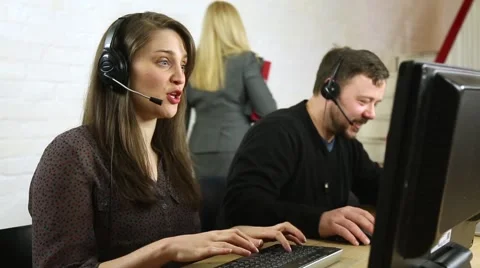 Friendly customer service call centre staff chatting to customers on headsets 스톡 동영상 47810629