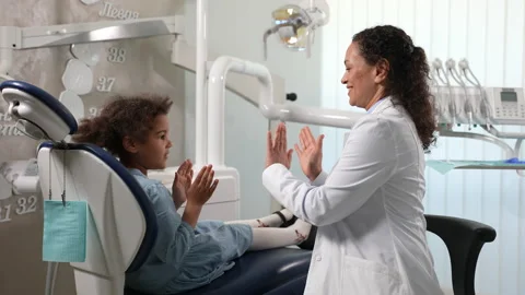 Friendly dentist playing pat-a-cake with child Stock Footage 156872496