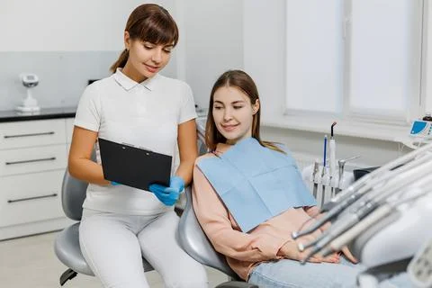 Friendly dentist with tablet explaining treatment to patient during teeth Stock Photos