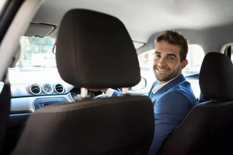 Friendly driver looking over his shoulder and smiling Stock Photos
