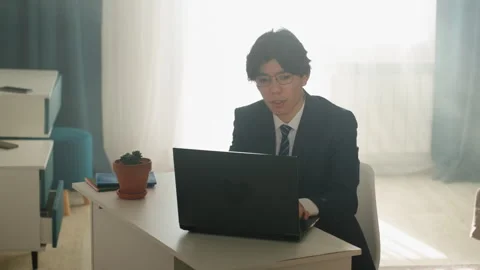 Friendly expert working at desk. Asian advisor engaged in client discussion Stock Footage 342059627
