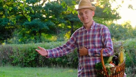 Friendly  farmer with a basket of vegetables on a background of nature Stock Footage 112928509