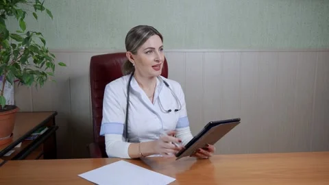 Friendly female doctor explains to the patient the issue of treatment using a Stock Footage 165621053