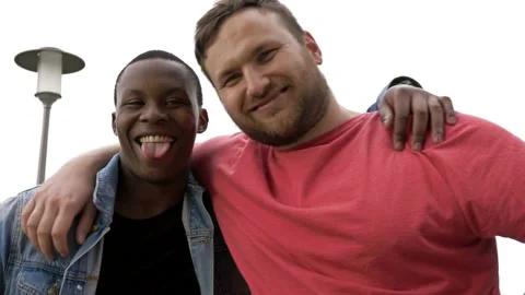 Friendly hug between a black guy and a white man. Concept of relationships and Video stock 133519903