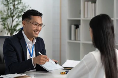 Friendly Insurance Advisor Explaining Options to Client Foto stock