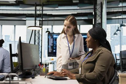 Friendly IT expert teaching intern to use artificial intelligence Foto stock