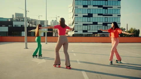 Friendly ladies performing tricks on retro roller skates Stock Footage 253997519