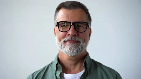 Friendly looking senior man taking off his glasses and smiling looking at camera Stock Footage 160462636