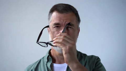 Friendly looking senior man taking off his glasses and smiling looking at camera Stock Footage 160462787