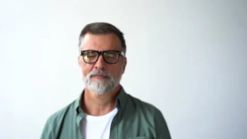 Friendly looking senior man taking off his glasses and smiling looking at camera Stock Footage 160463400