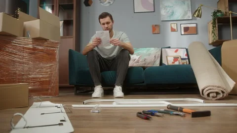 Friendly man are trying to understand how to build furniture in apartments Stock Footage 150438768