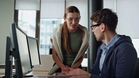 Friendly managers looking computer in office. It man coaching discussing code Stock Footage 242983989
