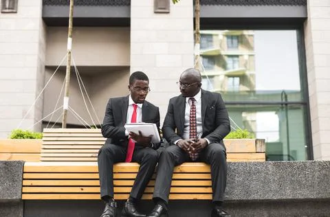 Friendly meeting of two dark-skinned African American businessman outdoors Stock Photos
