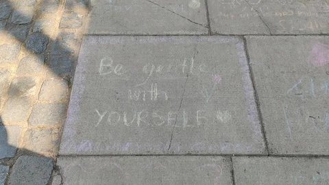 FRIENDLY MESSAGE ON PAVEMENT DURING COVID-19 'BE GENTLE WITH YOURSELF' Stock Footage 128144829
