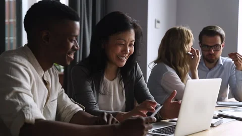 Friendly middle aged asian mentor teach african intern with computer Stock Footage 135726386