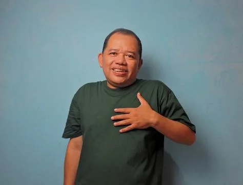 Friendly Middle Aged Man Smiling and Pointing to Chest Stock Photos