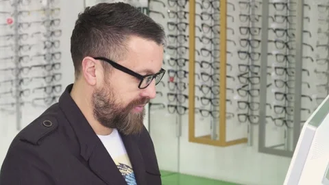 Friendly optometrist assisting customers while working on a computer Stock Footage 311672682