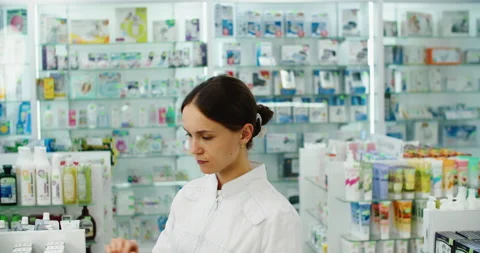 Friendly pharmacist does an inventory at a provided and modern pharmacy Stock Footage 221045306