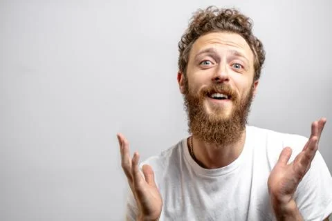 Friendly positive man looking at camera with doubting, questioning expression. Stock Photos