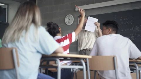Friendly Professor explaining maths exam exercise in high school classroom and Video stock 167836987