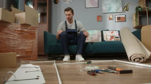 Friendly repairman worker are explaining how to build furniture in beautiful Stock Footage 149680315