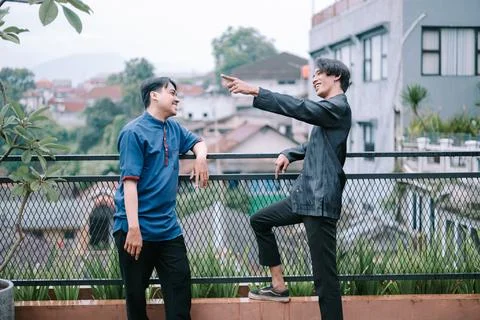 Friendly rooftop interaction between two stylish young men Stock Photos