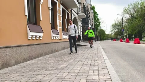 Friendly runner picks up dropped object of pedestrian and returns the lost item Stock Footage 192060110