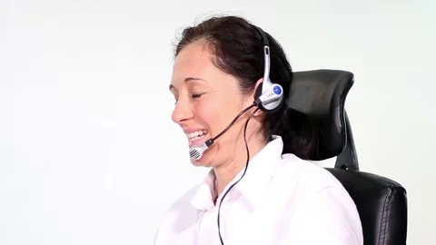 Friendly secretary with headset in customer talk smiles into the camera Stock Footage 70871704