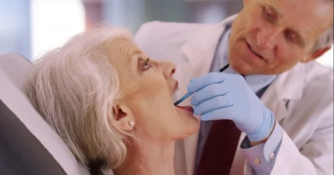 Friendly senior dentist examining elderly woman's teeth Stock-Footage 75020254