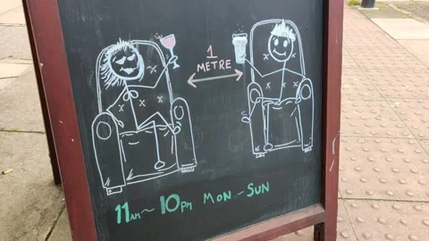 FRIENDLY SIGN OUTSIDE PUB ADVISING CUSTOMERS ABOUT SOCIAL DISTANCING RULES UK 4K Stock Footage 144438013