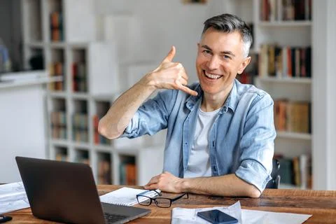 Friendly sociable confident middle aged gray-haired Caucasian male freelancer Stock Photos